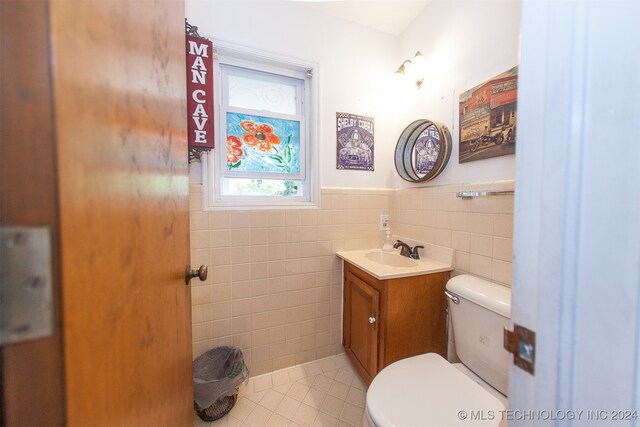 bathroom with vanity, tile walls, tile patterned flooring, and toilet