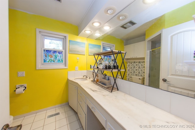 bathroom with tile patterned flooring, backsplash, a shower with door, and vanity