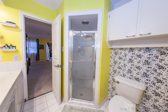 bathroom with tile patterned flooring, vanity, toilet, and an enclosed shower