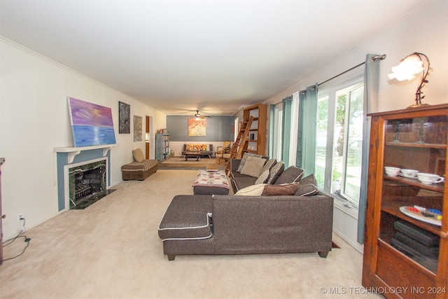 carpeted living room with ornamental molding, ceiling fan, and a premium fireplace