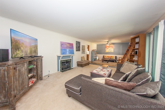 living room with ornamental molding, a premium fireplace, light colored carpet, and ceiling fan