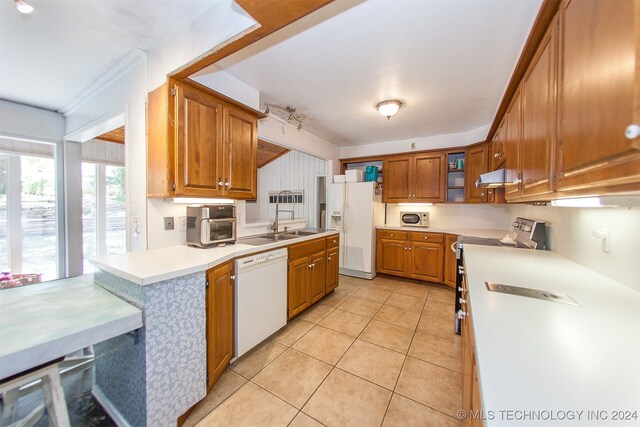 kitchen with light tile patterned flooring, sink, and white appliances