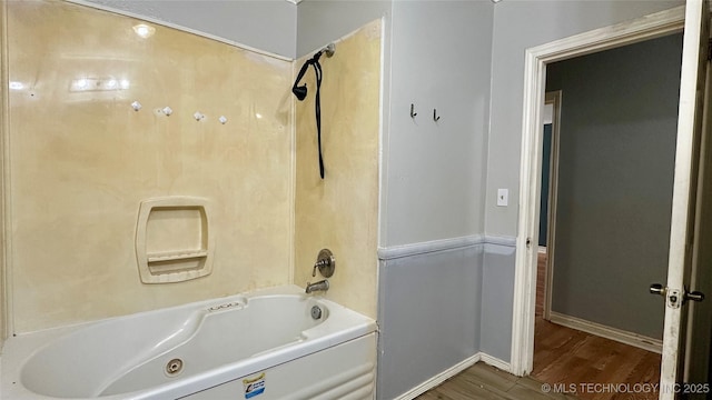 bathroom with shower / bath combination, baseboards, and wood finished floors