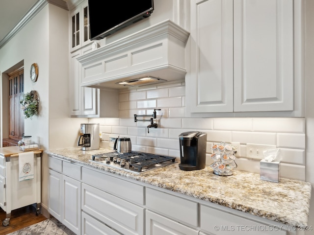 kitchen featuring light stone counters, white cabinets, backsplash, and dark hardwood / wood-style flooring