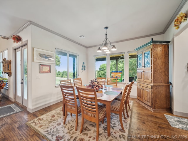 dining area with ornamental molding, a notable chandelier, dark wood-type flooring, and french doors