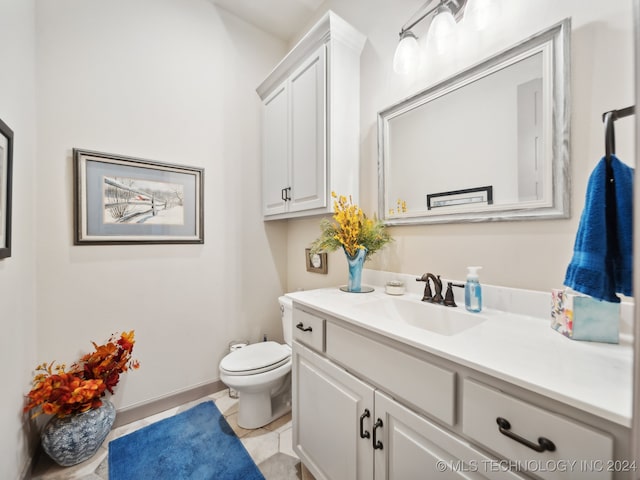 bathroom featuring vanity, tile patterned flooring, and toilet