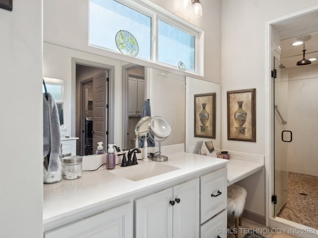 bathroom featuring a shower with door and vanity