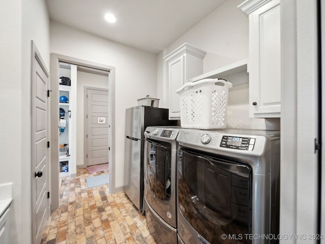 clothes washing area featuring cabinets and independent washer and dryer