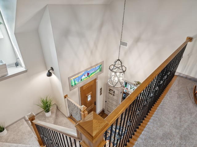 stairs featuring high vaulted ceiling and a notable chandelier