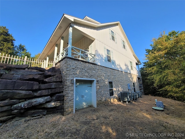 view of home's exterior with a balcony, central AC, and a garage