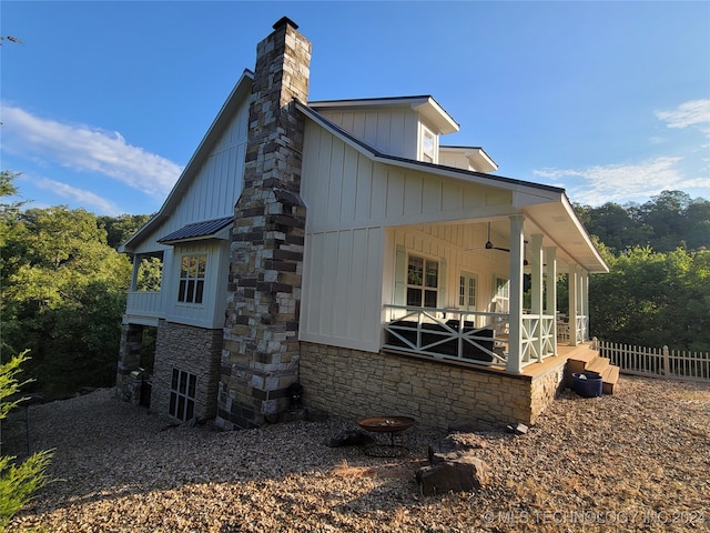 view of side of property with ceiling fan and a porch