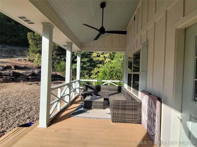 wooden terrace with ceiling fan and an outdoor living space