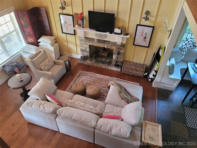 living room with a fireplace, dark wood-type flooring, and a healthy amount of sunlight