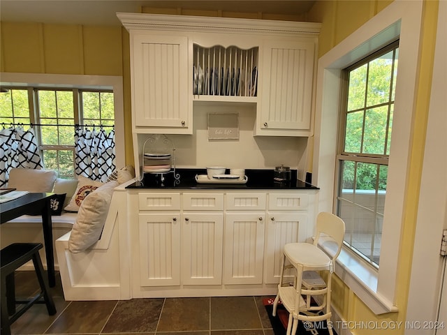 kitchen featuring dark tile patterned floors and white cabinets