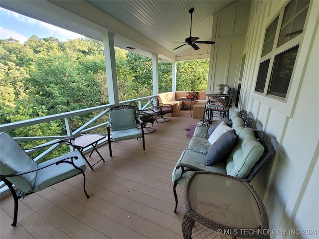 wooden deck featuring an outdoor living space and ceiling fan