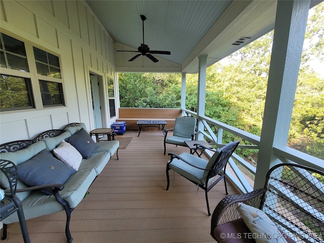 wooden deck featuring an outdoor living space and ceiling fan