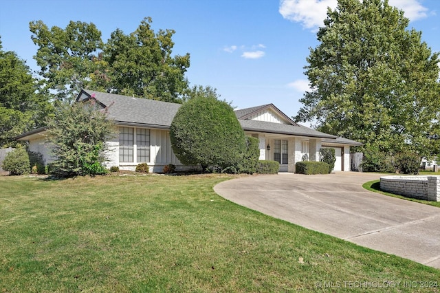 single story home featuring a front yard and a garage