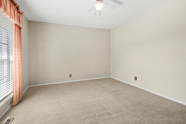 spare room featuring light carpet and ceiling fan