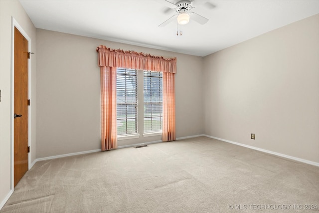 spare room with ceiling fan and light colored carpet