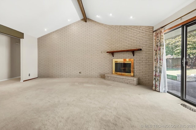 unfurnished living room featuring lofted ceiling with beams, a fireplace, light colored carpet, and brick wall