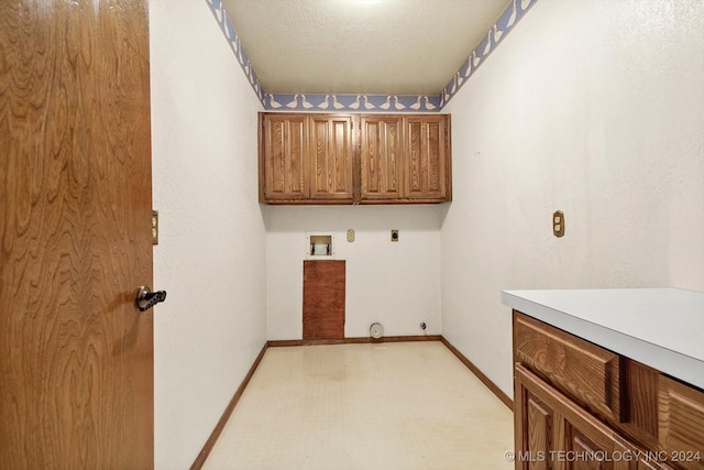 clothes washing area featuring washer hookup, hookup for an electric dryer, cabinets, and a textured ceiling