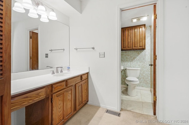 bathroom featuring toilet, vanity, and tile patterned floors