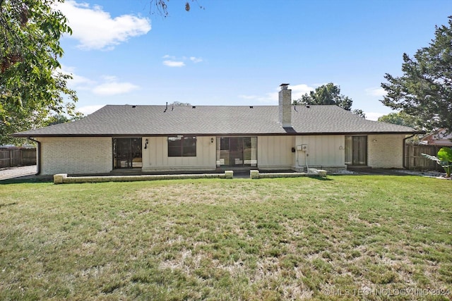 back of property with a patio area and a yard