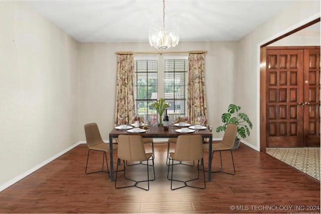 dining area featuring a notable chandelier and dark hardwood / wood-style flooring