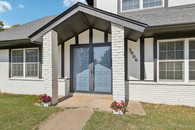 view of exterior entry with a lawn