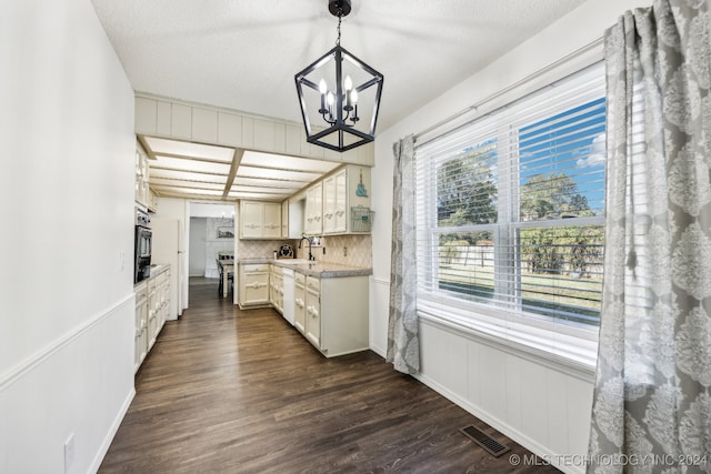 kitchen with tasteful backsplash, dark hardwood / wood-style flooring, pendant lighting, and white cabinets