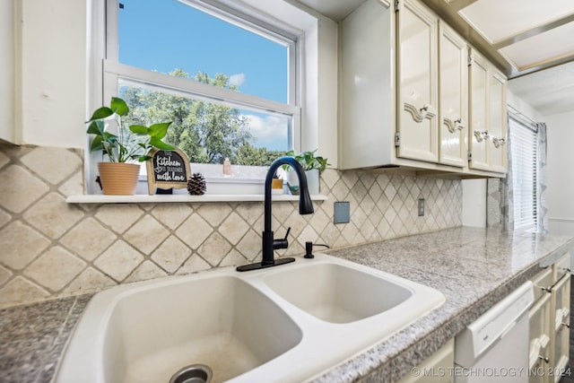 kitchen featuring dishwasher, decorative backsplash, sink, and white cabinetry