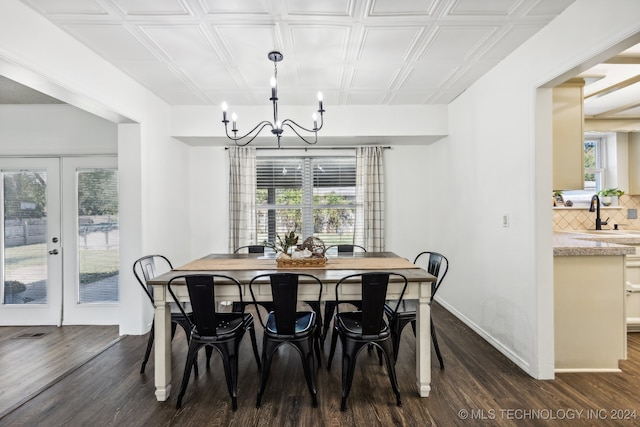 dining area featuring a notable chandelier, dark hardwood / wood-style floors, french doors, and sink