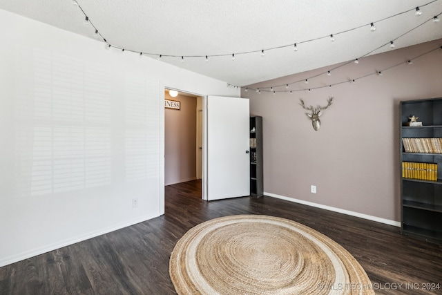 empty room featuring a textured ceiling and dark wood-type flooring