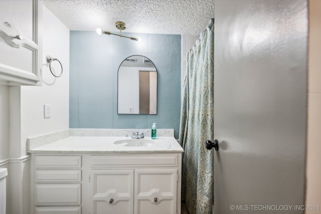 bathroom with a textured ceiling and vanity