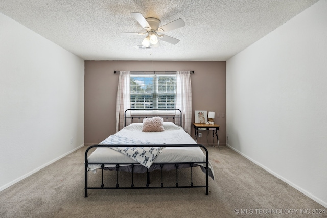 bedroom with light carpet, ceiling fan, and a textured ceiling