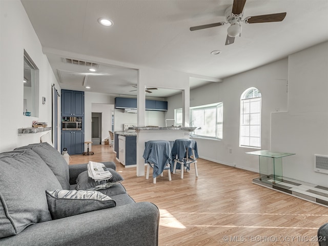 living room with ceiling fan and light wood-type flooring