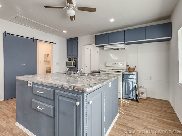 kitchen featuring an island with sink, blue cabinetry, white electric range, light wood-type flooring, and a barn door