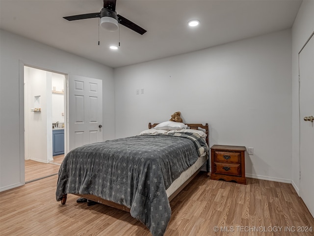 bedroom with connected bathroom, ceiling fan, and light hardwood / wood-style flooring