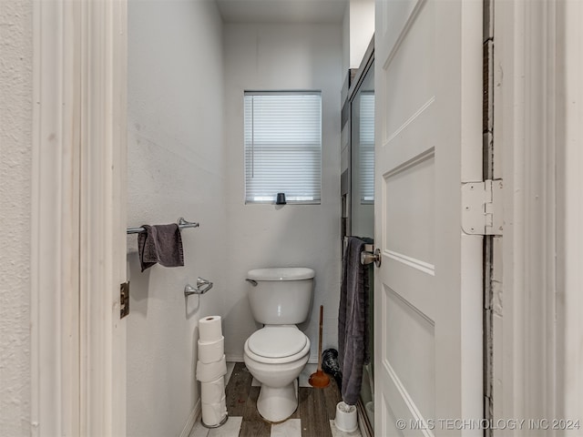 bathroom featuring wood-type flooring and toilet