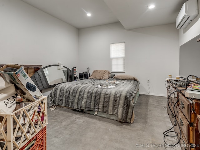 bedroom featuring an AC wall unit and concrete floors