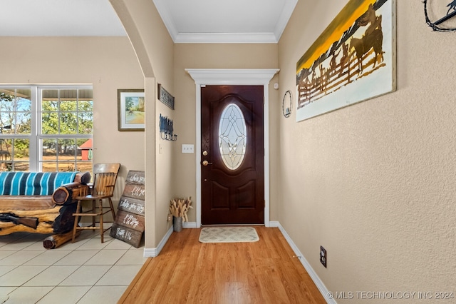 doorway to outside with light hardwood / wood-style flooring and ornamental molding