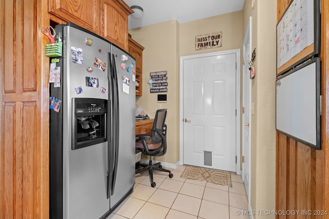 kitchen with light tile patterned floors and stainless steel fridge