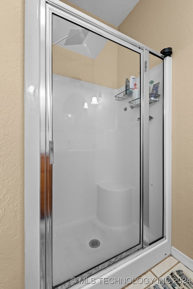 bathroom with walk in shower and tile patterned floors