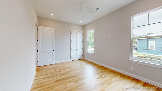 empty room featuring light hardwood / wood-style flooring, ceiling fan, and plenty of natural light