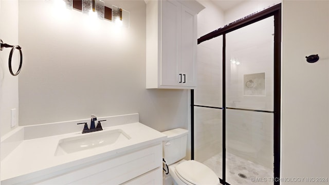 bathroom featuring vanity, toilet, and a shower with shower door