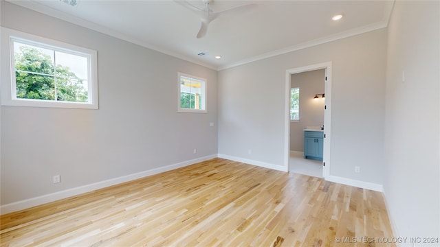 unfurnished room featuring ornamental molding, light hardwood / wood-style flooring, and a wealth of natural light