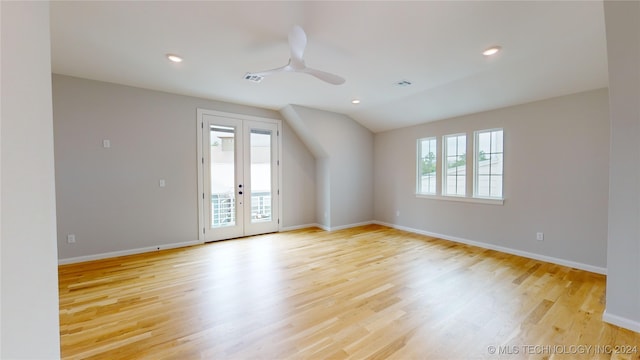 empty room with light wood-type flooring, vaulted ceiling, french doors, and plenty of natural light