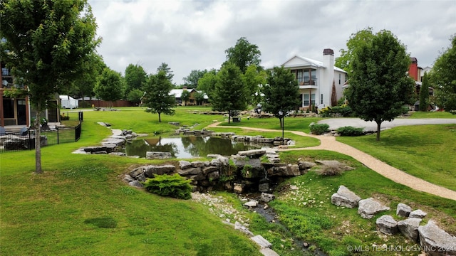 surrounding community with a water view and a yard