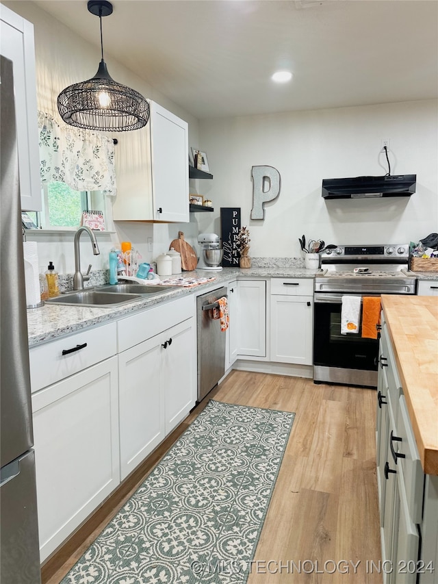 kitchen with sink, butcher block countertops, light hardwood / wood-style flooring, white cabinetry, and appliances with stainless steel finishes