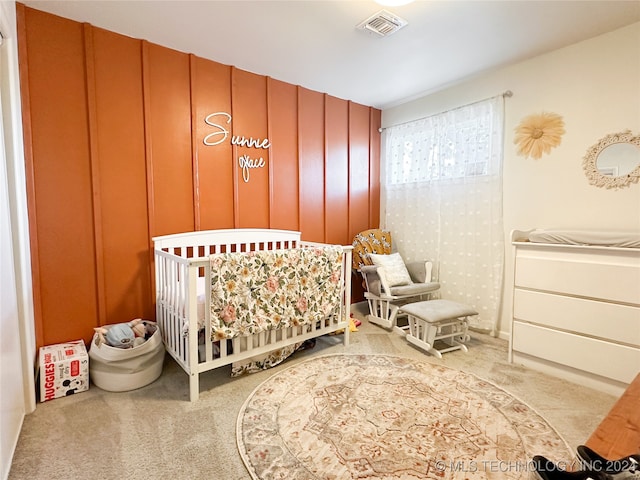 bedroom featuring a crib and light carpet